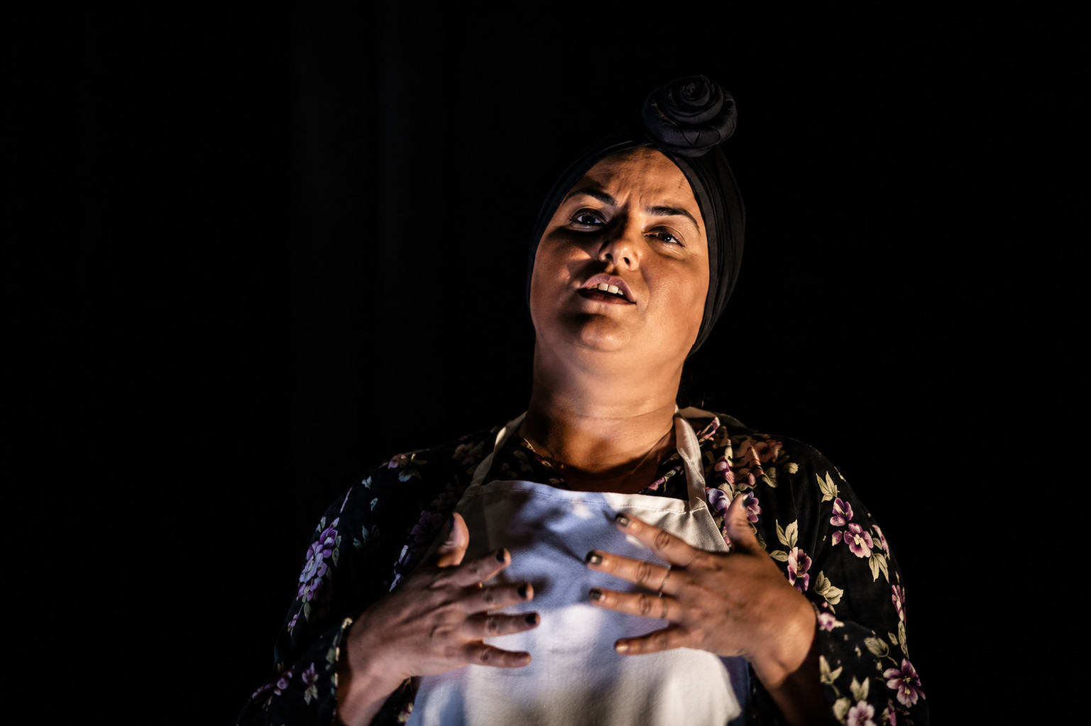 Atriz em close dramático com figurino floral