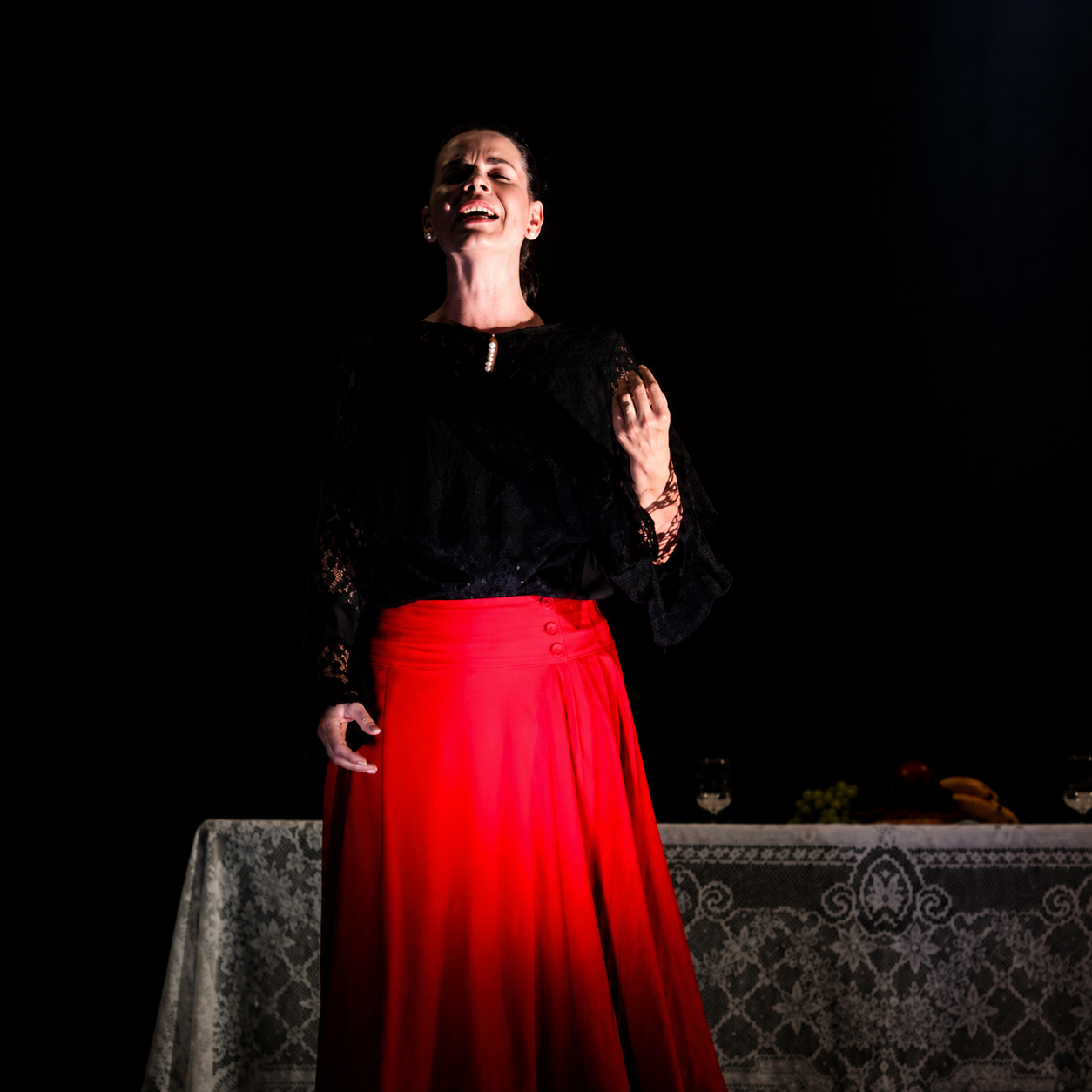 Atriz em performance com saia vermelha no palco